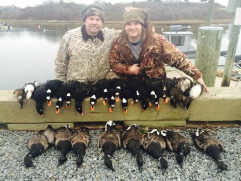 Two hunters displays the sea ducks they shot
