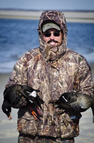 Hunter with white winged scoter and a hen eider